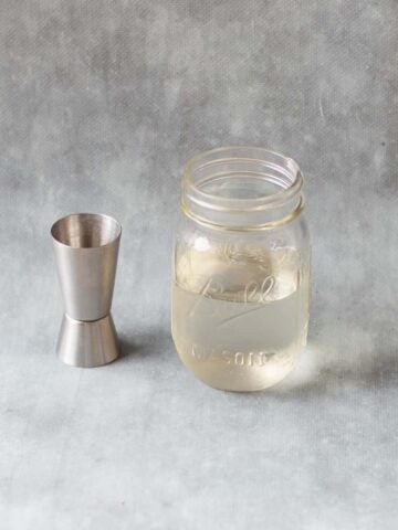 sugar syrup in glass jar with silver spirit measurer