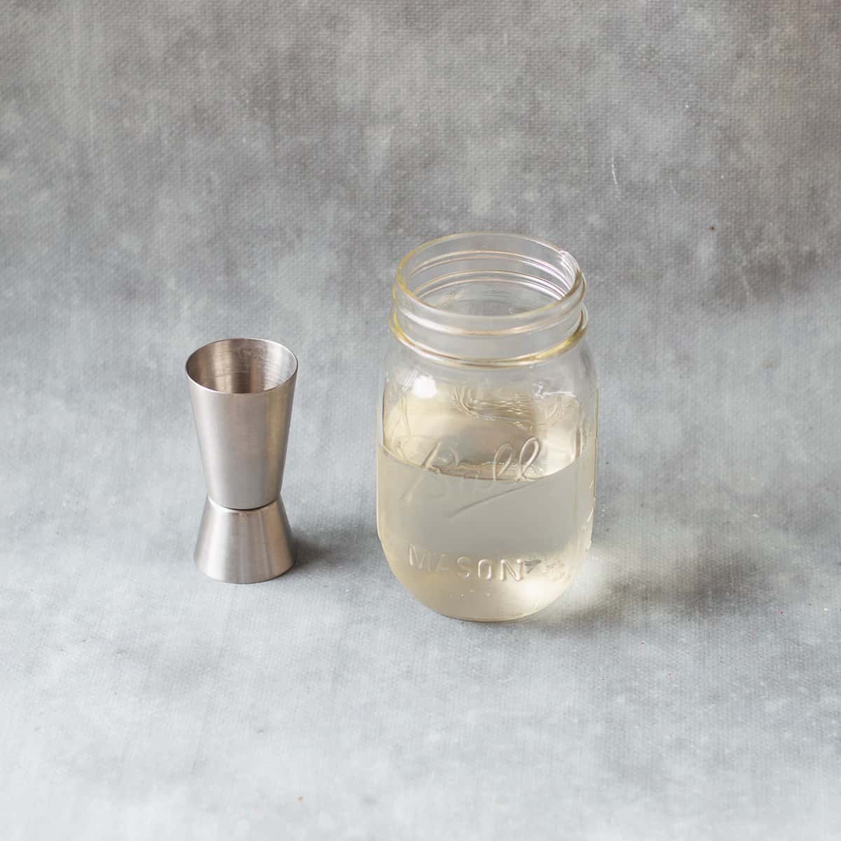 sugar syrup in glass jar with silver spirit measurer