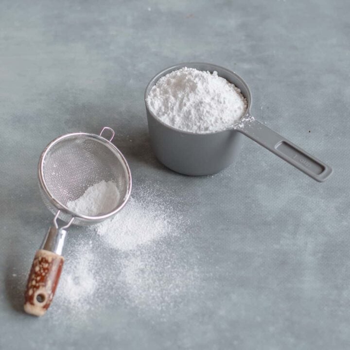 Icing sugar in a grey cup with sifter