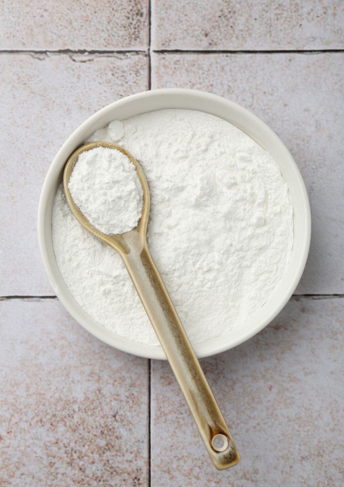 A bowl of icing sugar with a spoon.