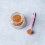 chai spice mix in glass jar with pink spoon