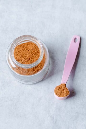 chai spice mix in glass jar with pink spoon