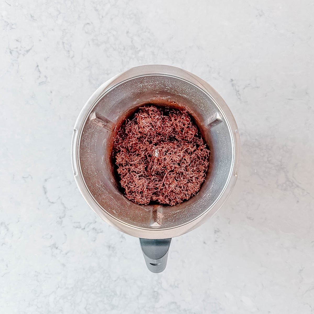 Chocolate and coconut mixed together in a thermomix bowl.