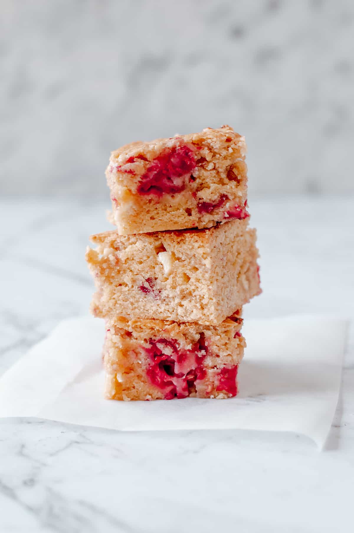 3 white chocolate and raspberry blondies stacked on top of each other