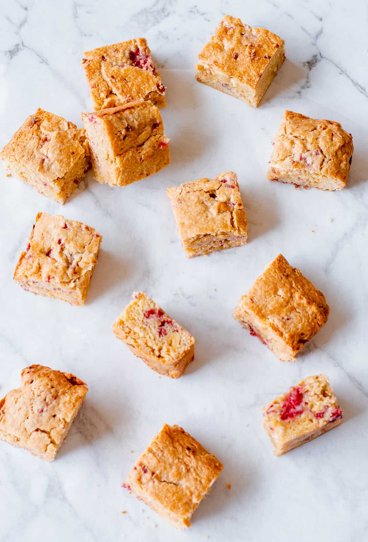 white chocolate and rasberry blondies on a white background