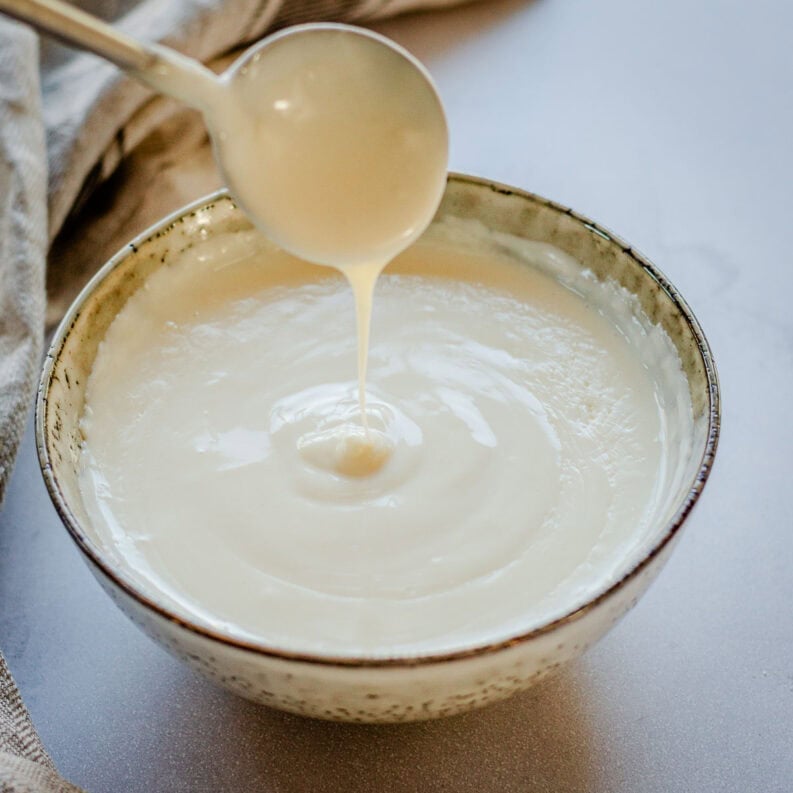 Bechamel Sauce in a bow with spoon.