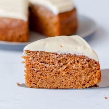Close up image of a slice of carrot cake with cream cheese icing.