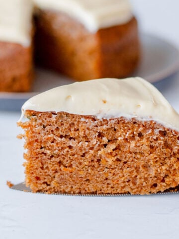 Close up image of a slice of carrot cake with cream cheese icing.