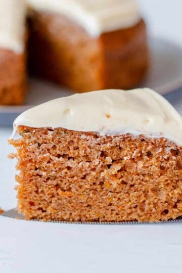 Close up image of a slice of carrot cake with cream cheese icing.