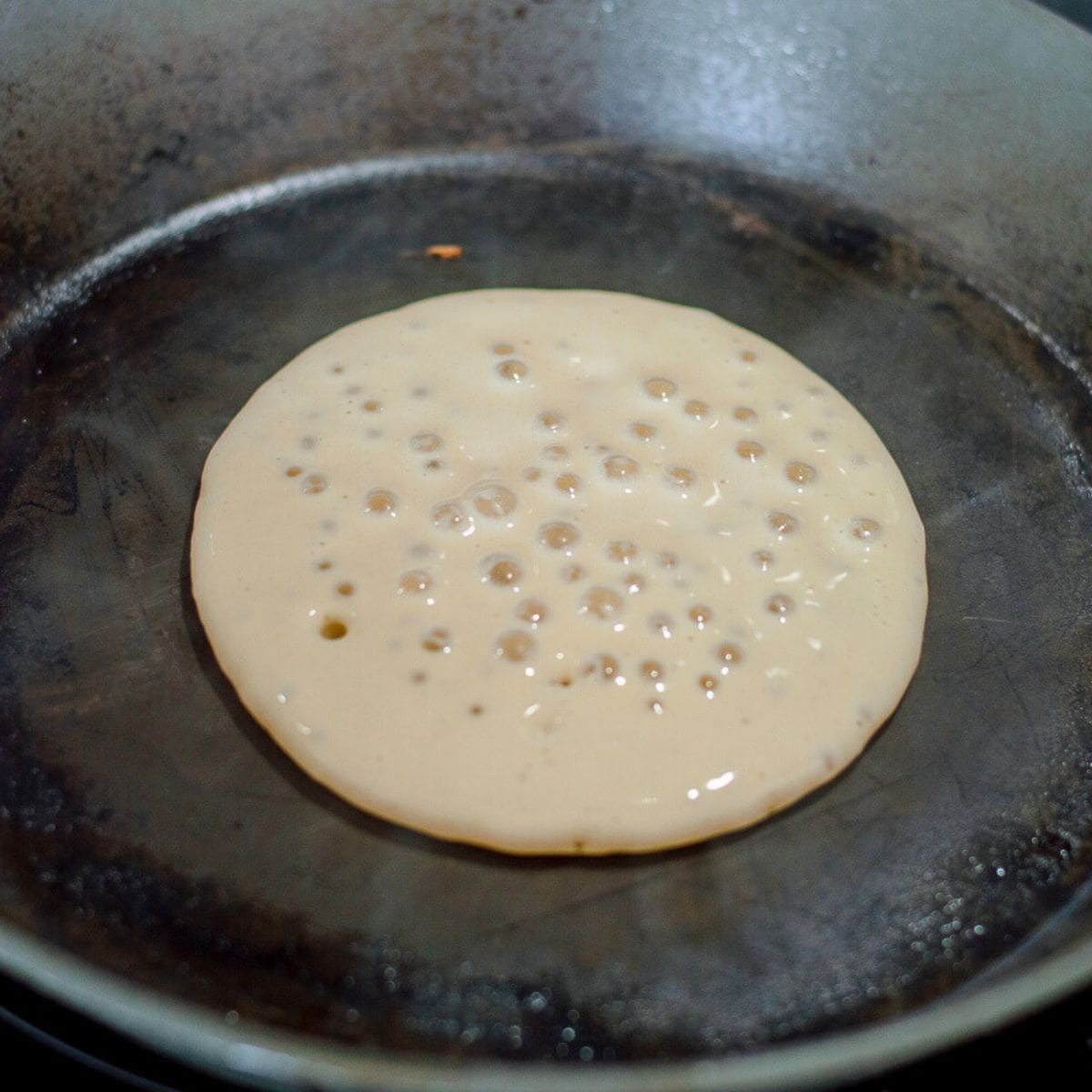 Raw pancake in a frying pan.