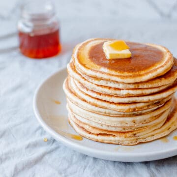 Pancake stack with butter and maple syrup.