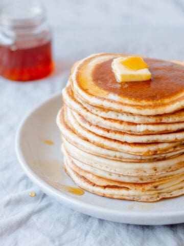 Pancake stack with butter and maple syrup.