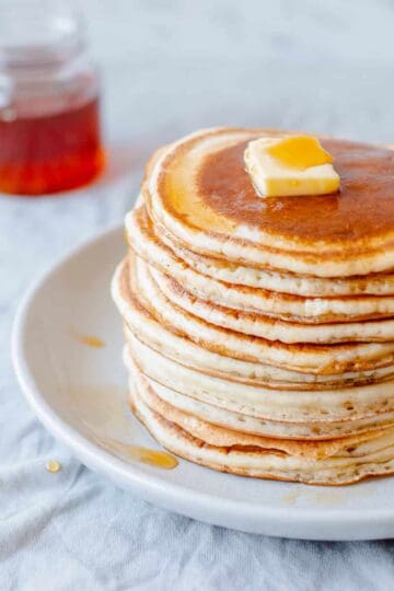 Pancake stack with butter and maple syrup.