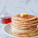 A pancake stack with butter and maple syrup.