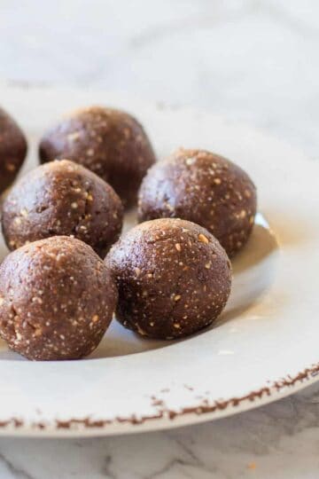 Peanut butter bliss balls on a white plate.
