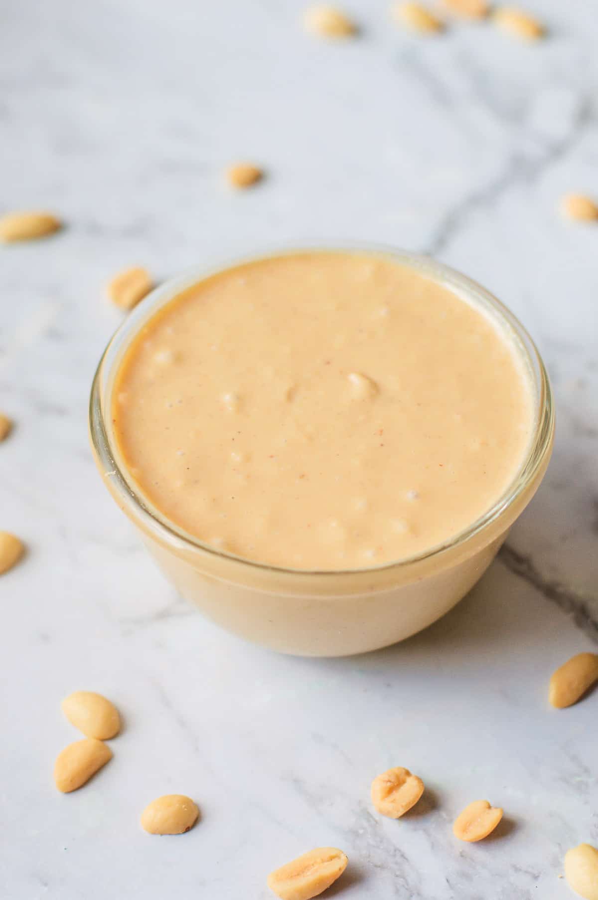 Homemade peanut butter in a glass bowl.