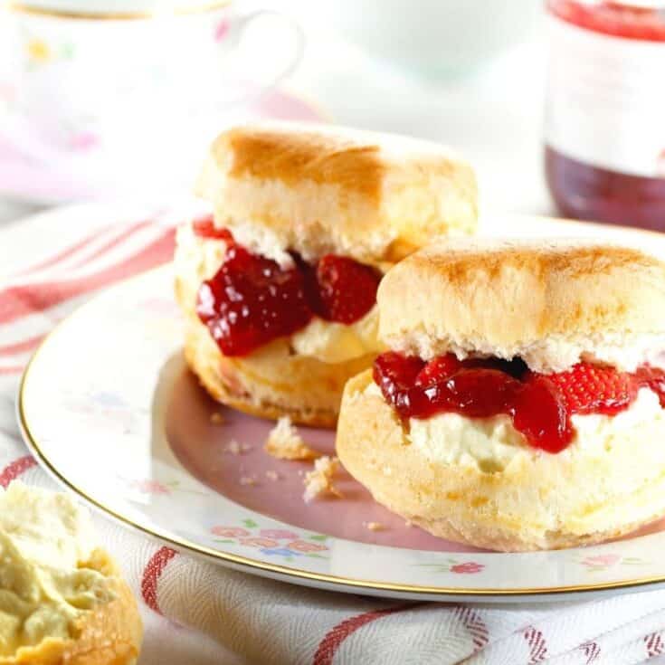 Scones with jam and cream on a plate.