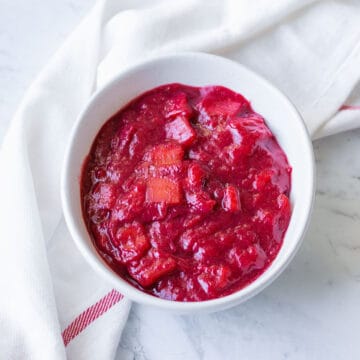 Stewed rhubarb compote in a white bowl.