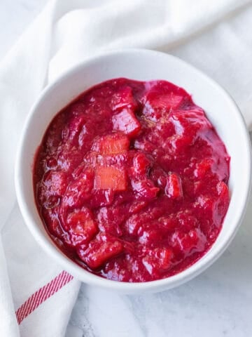 Stewed rhubarb compote in a white bowl.
