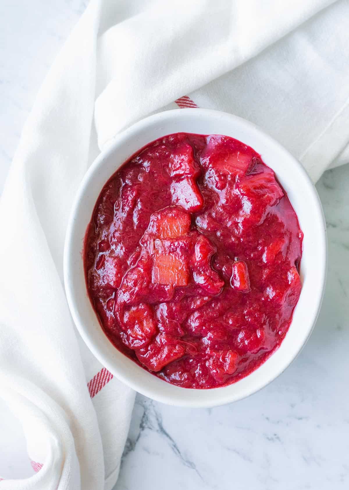 Overhead photo of stewed rhubarb in a white bowl.