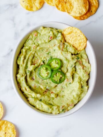 Guacamole in a bowl with tortilla chips.