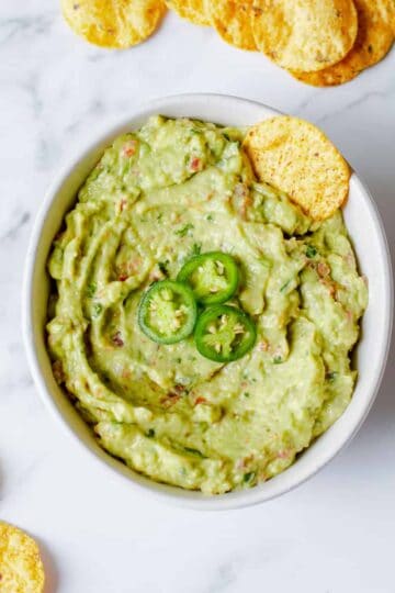 Guacamole in a bowl with tortilla chips.
