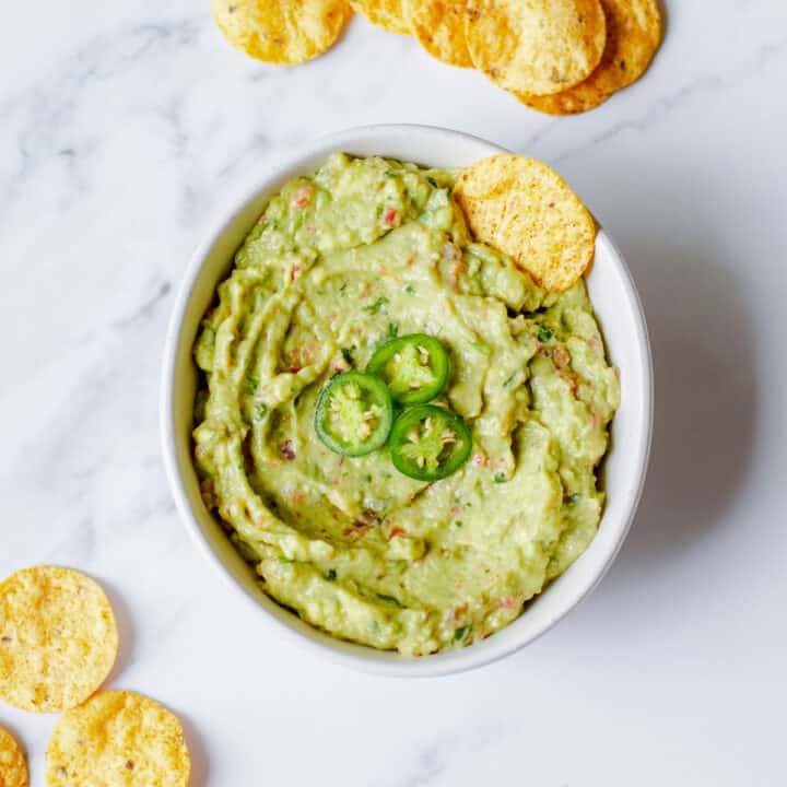 Guacamole in a bowl with tortilla chips.