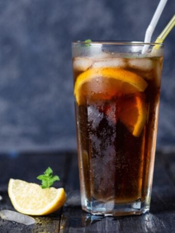Long Island Iced Tea in a tall glass with lemon wedge.