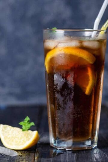 Long Island Iced Tea in a tall glass with lemon wedge.