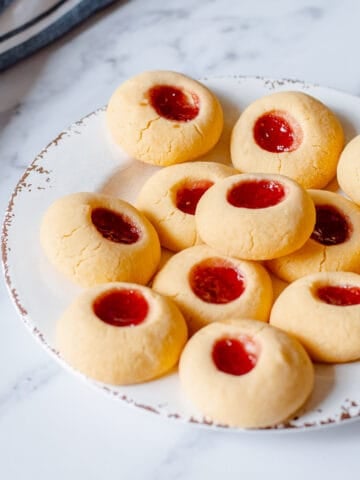 Home made raspberry Jam Drops sittting on a white plate.