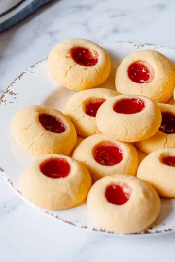 Home made raspberry Jam Drops sitting on a white plate.
