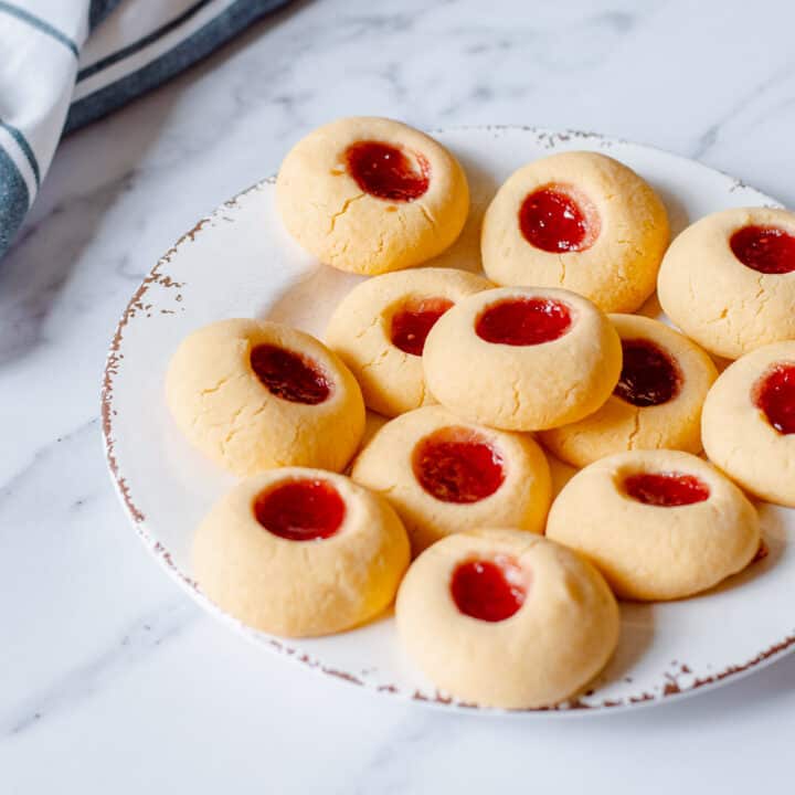 Home made raspberry Jam Drops sittting on a white plate.