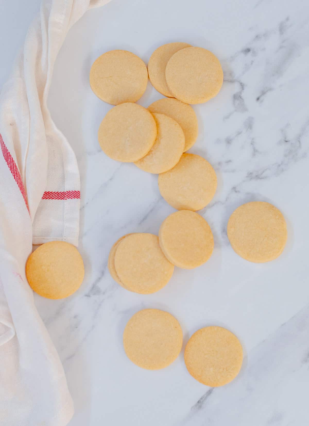 Homemade sugar cookies on a white marble background.