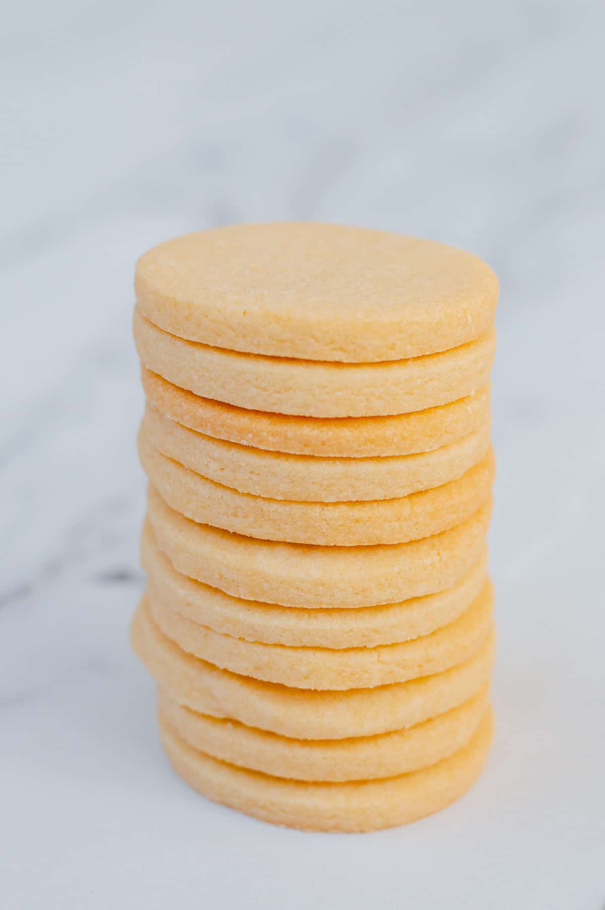 A stack of Thermomix sugar cookies on a white marble background.