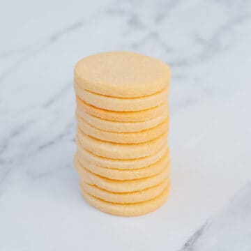 A stack of sugar cookies sitting on a marble background.