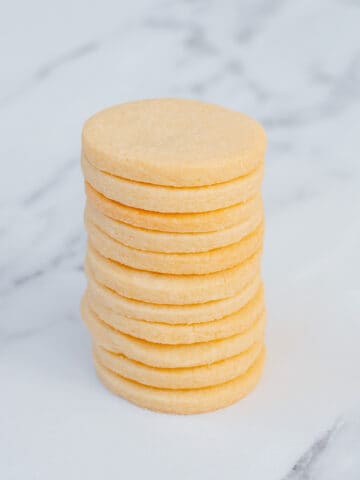 A stack of sugar cookies sitting on a marble background.