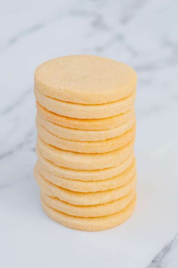 A stack of sugar cookies sitting on a marble background.