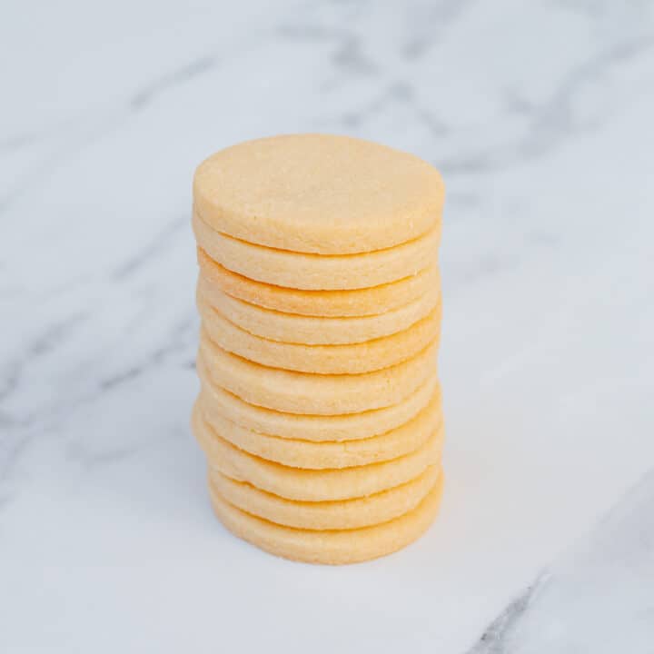 A stack of sugar cookies sitting on a marble background.