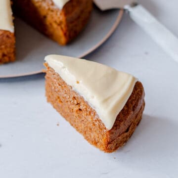 A slice of carrot cake with cream cheese icing on top.