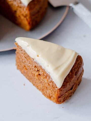 A slice of carrot cake with cream cheese icing on top.