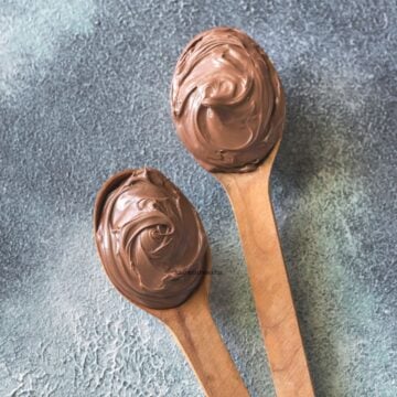 Chocolate buttercream icing on 2 wooden spoons.