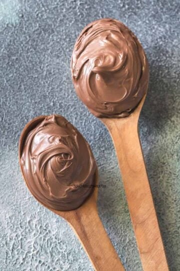 Chocolate buttercream icing on 2 wooden spoons.