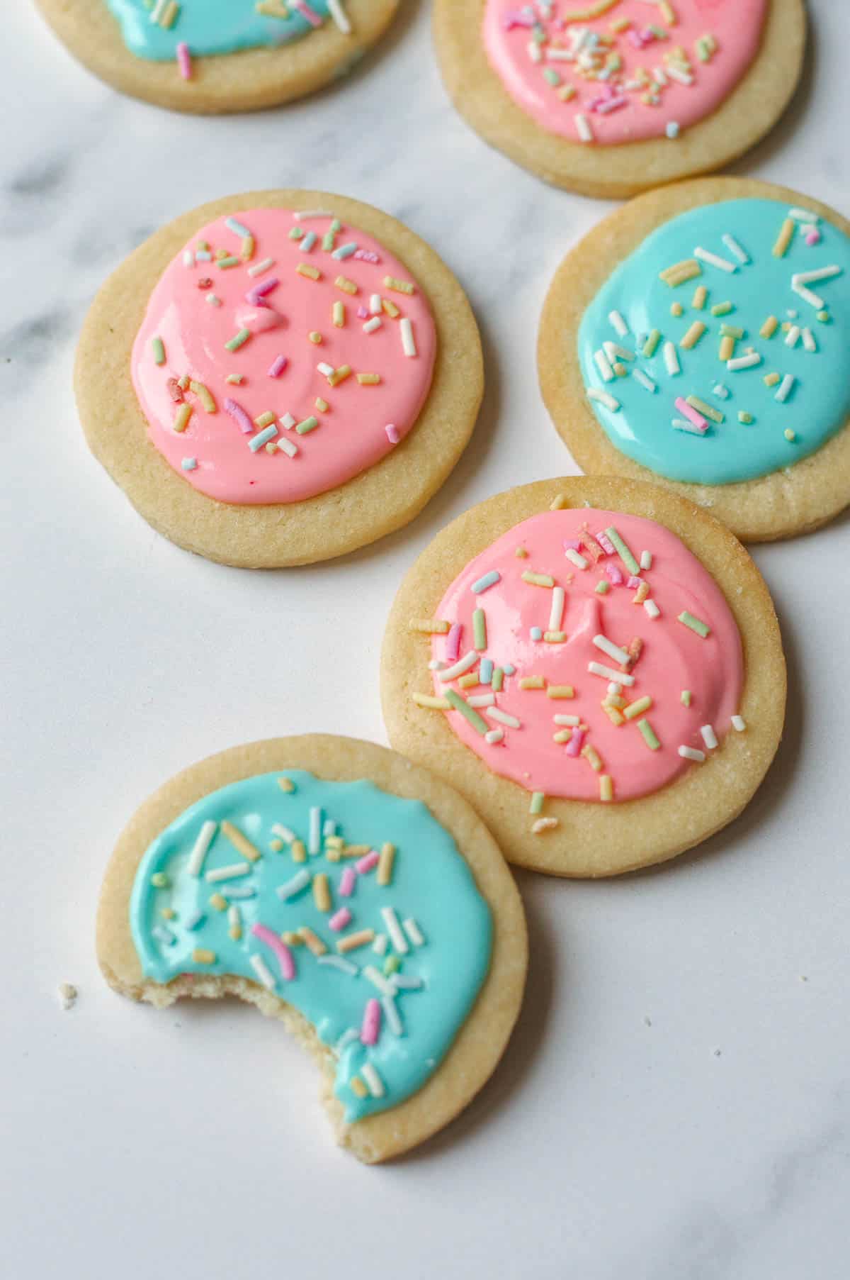 Sugar Cookies decorated in pink and blue icing with sprinkles.