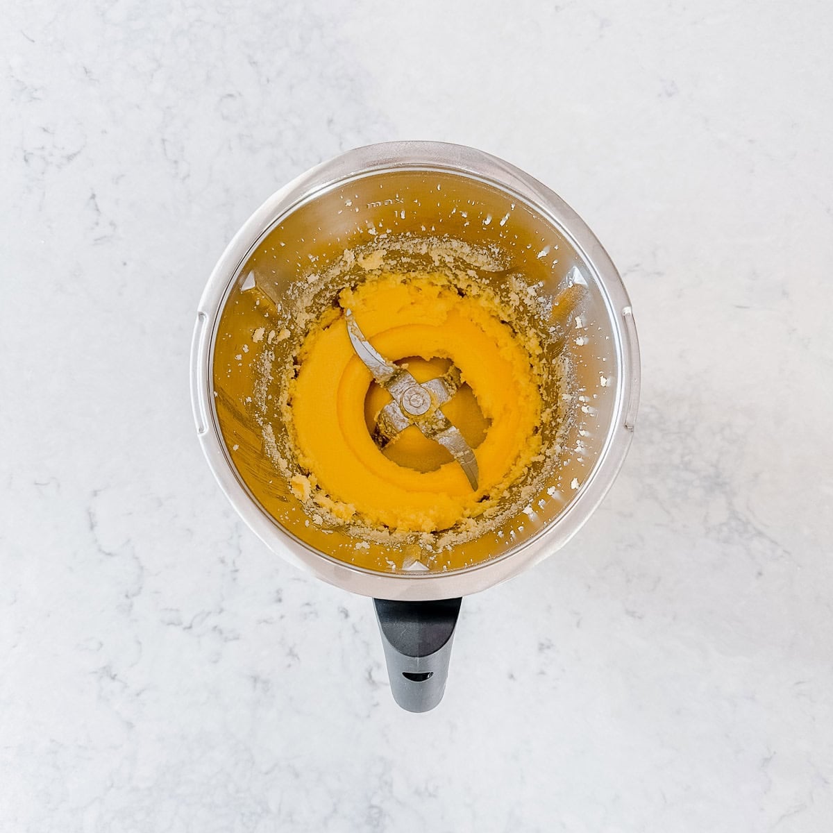 A top down view of butter and sugar creamed together in a Thermomix bowl.