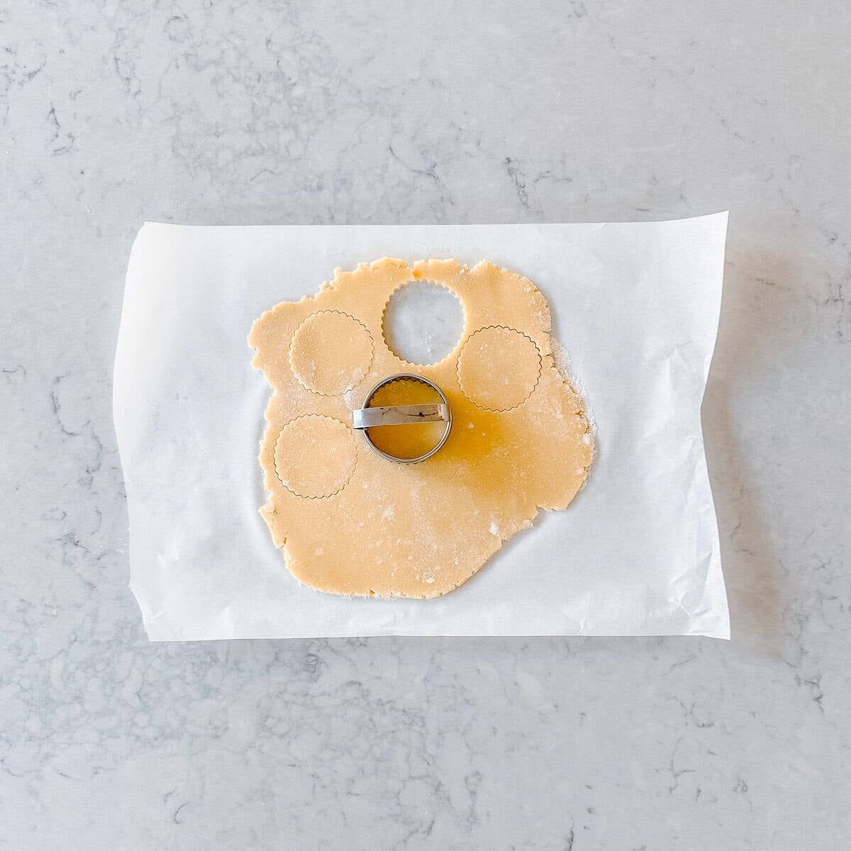 Rolled out cookie dough, which a cookie cutter.