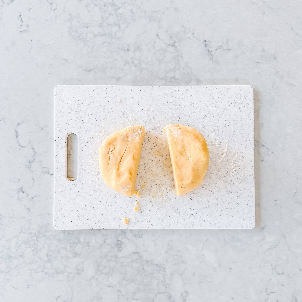 A ball of cookie dough batter divided in half.