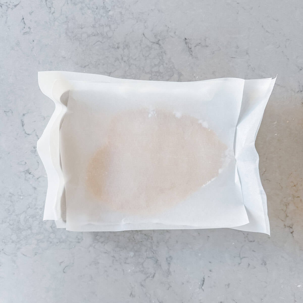 Cookie dough rolled out and covered with a sheet of baking paper.