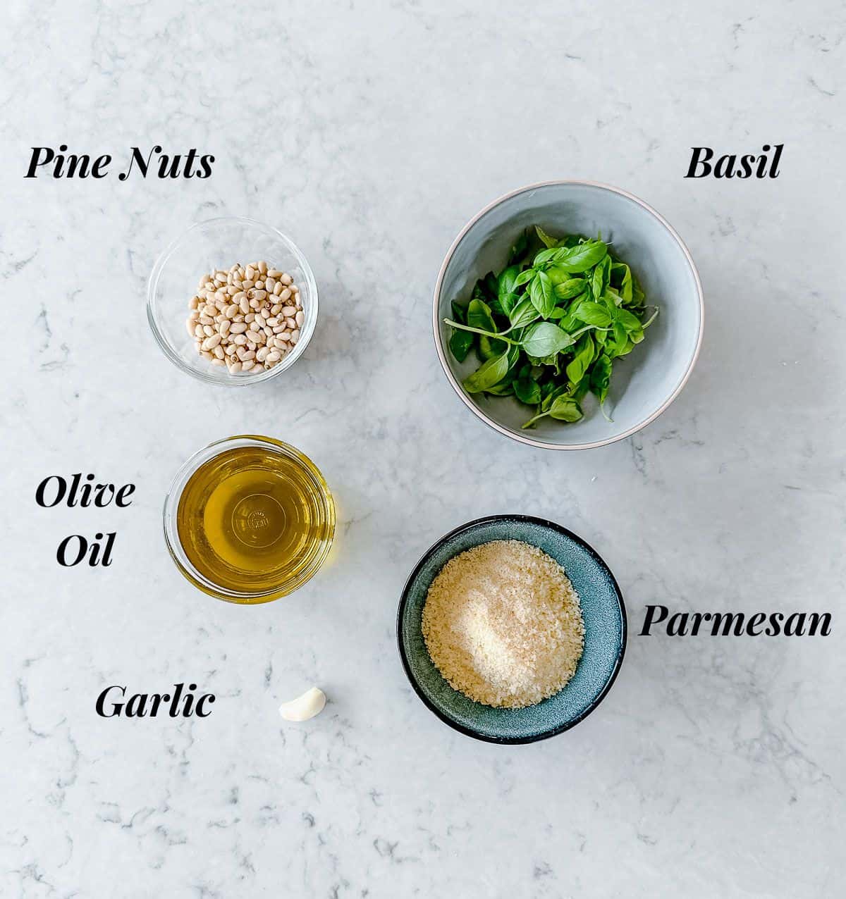 A collection of ingredients used to make Basil Pesto.