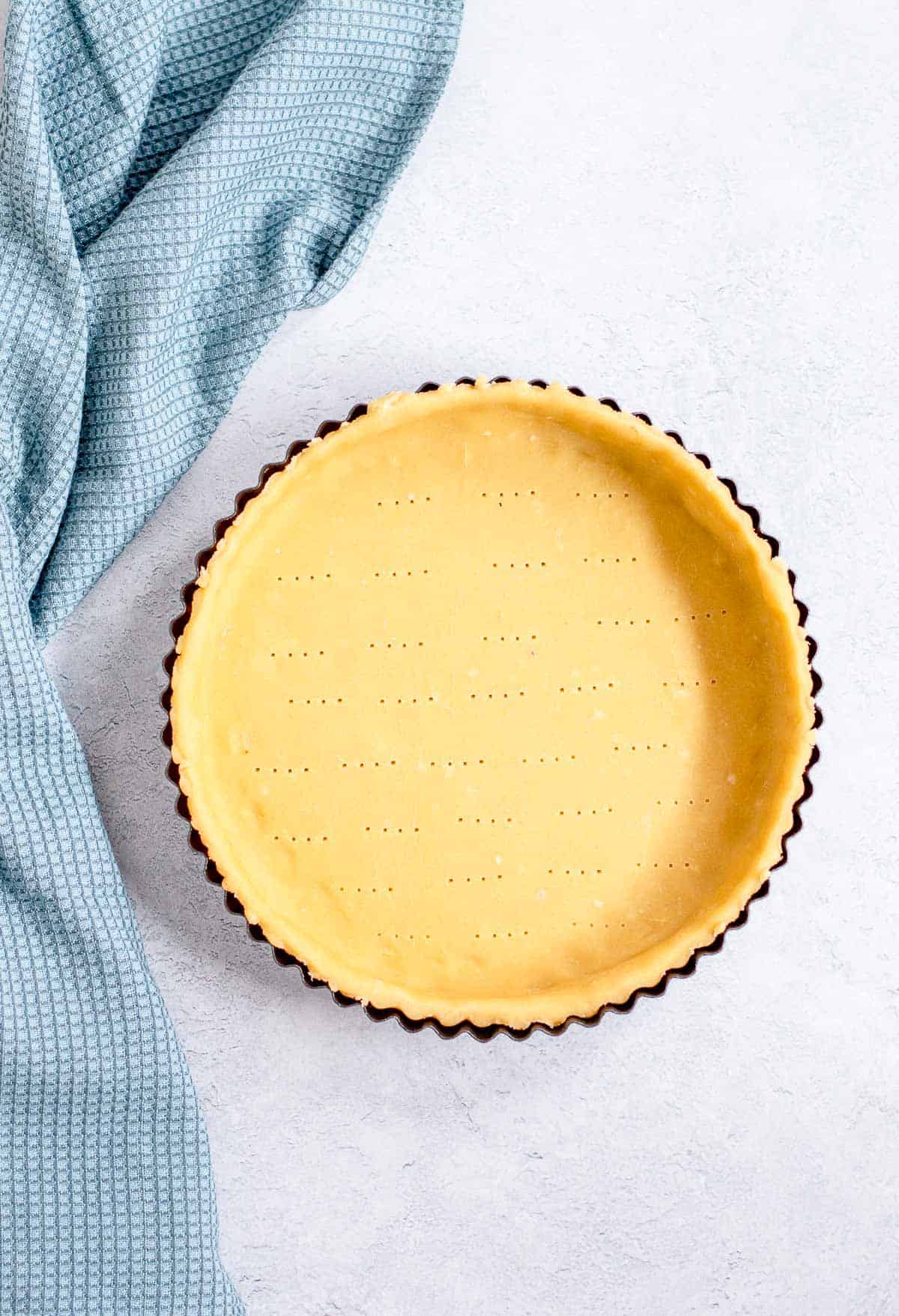 Overhead image of shortcrust pastry in a tart tin.