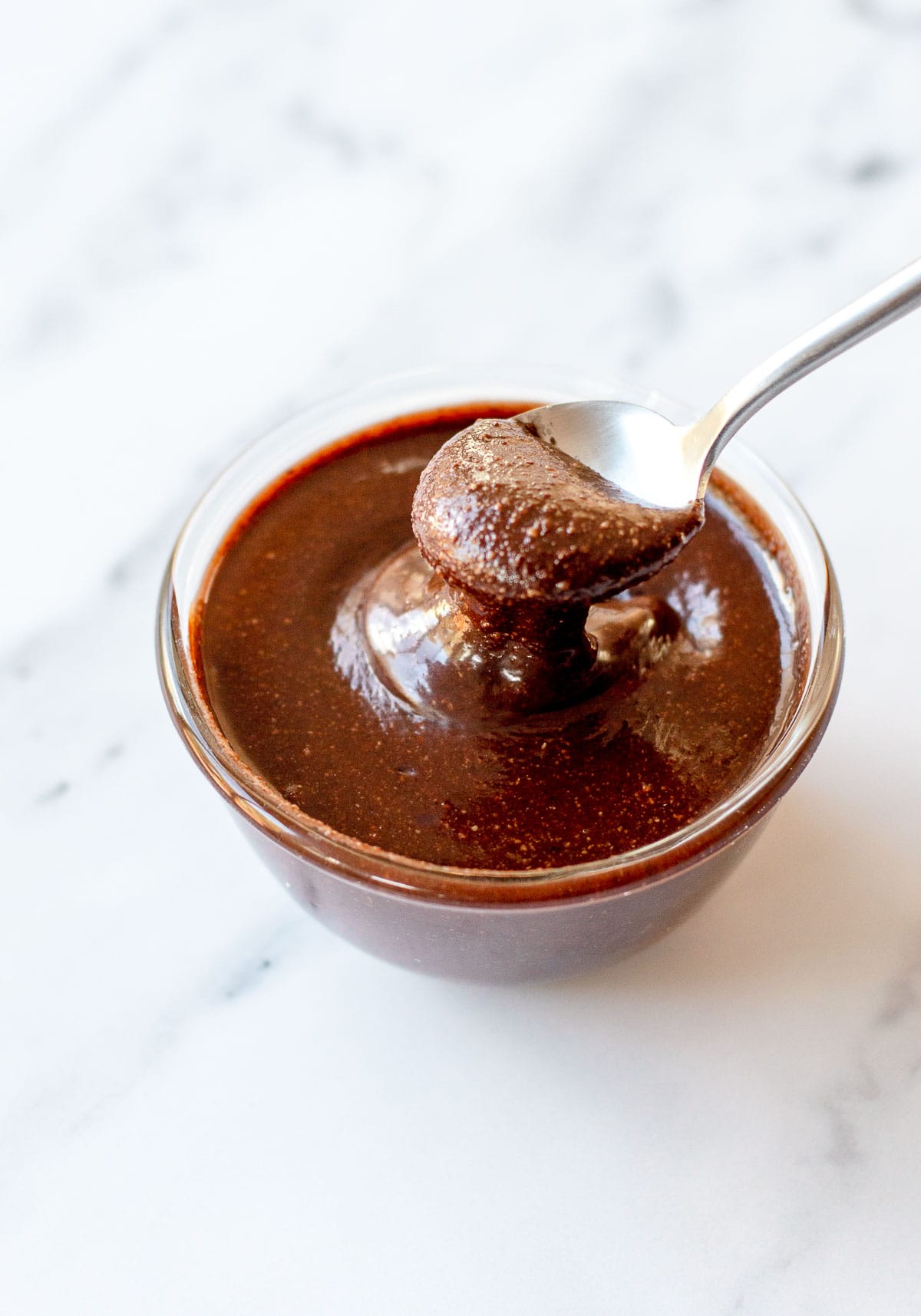 Image of Nutella in a glass bowl with a spoon.